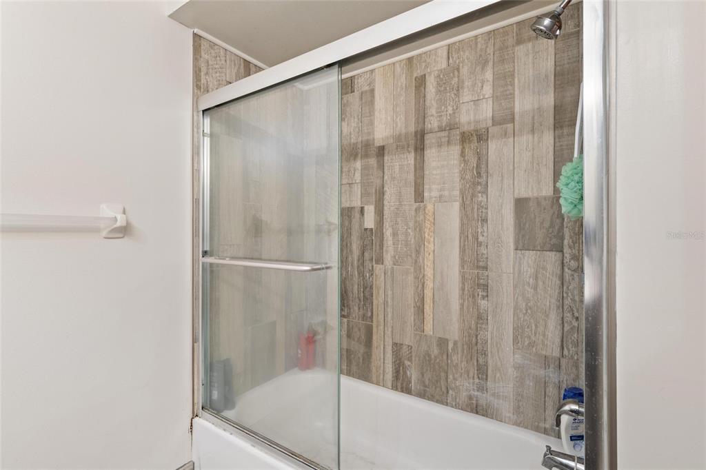 1801 East Lake Road South, Unit 4E Palm Harbor, FL 34685 - Photo 17 of 26 a bathroom with a shower and a bath tub