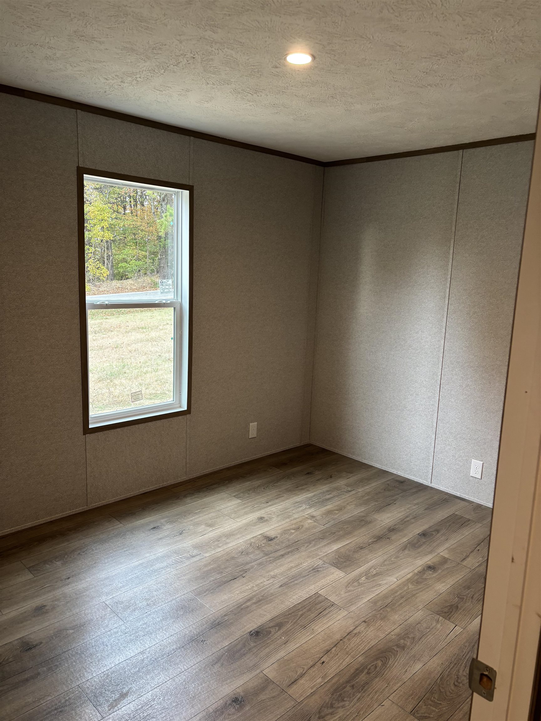 1131 Hobe Webb Road Ripley, TN 38063 - Photo 11 of 27 an empty room with wooden floor and windows