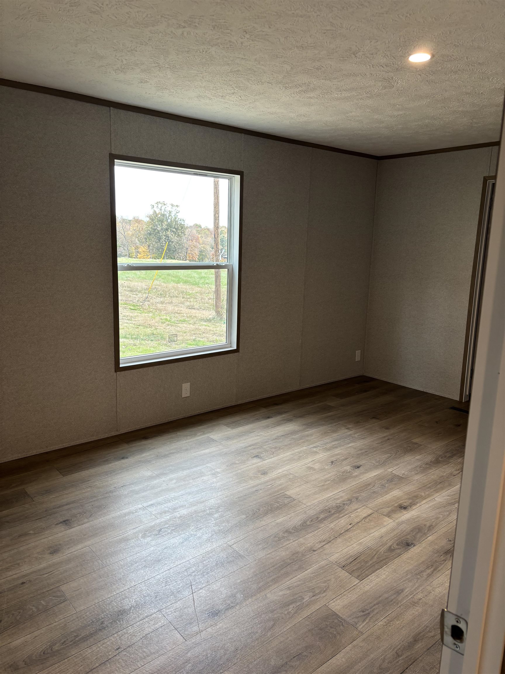 1131 Hobe Webb Road Ripley, TN 38063 - Photo 22 of 27 an empty room with wooden floor and windows