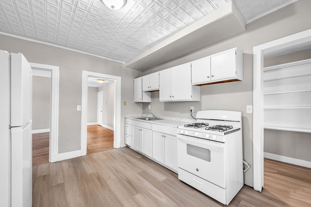 92 Woodside Terrace, Unit 3R Springfield, MA 01108 - Photo 2 of 42 a kitchen with stainless steel appliances a stove a sink and white cabinets