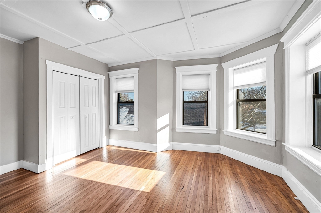 92 Woodside Terrace, Unit 3R Springfield, MA 01108 - Photo 23 of 42 an empty room with wooden floor and windows
