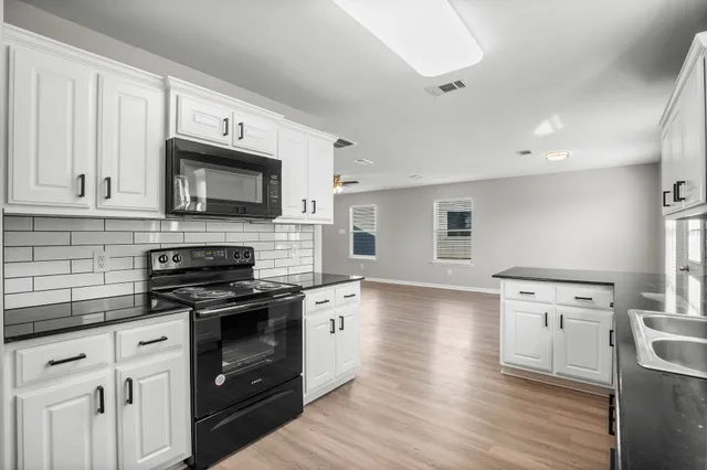 a kitchen with a stove a sink and a microwave