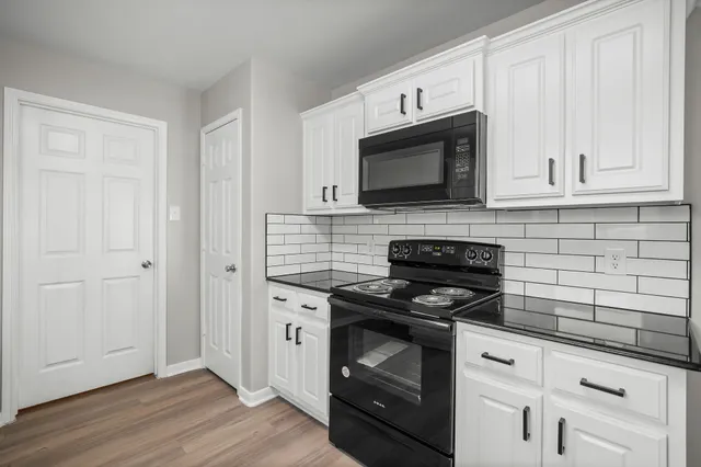 a kitchen with cabinets stainless steel appliances and wooden floor