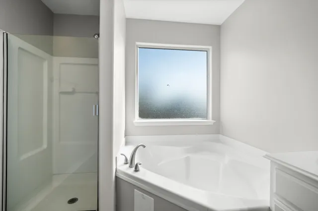a white bath tub sitting next to a shower