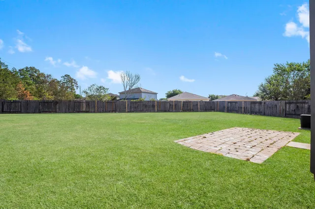 a view of yard with swimming pool and wooden fence