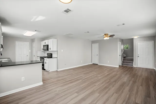 a view of kitchen with stove and cabinets