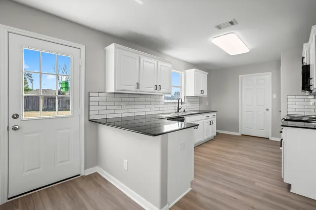 a kitchen with granite countertop a sink and a stove top oven