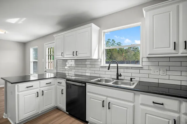 a kitchen with stainless steel appliances granite countertop a sink a stove and cabinets