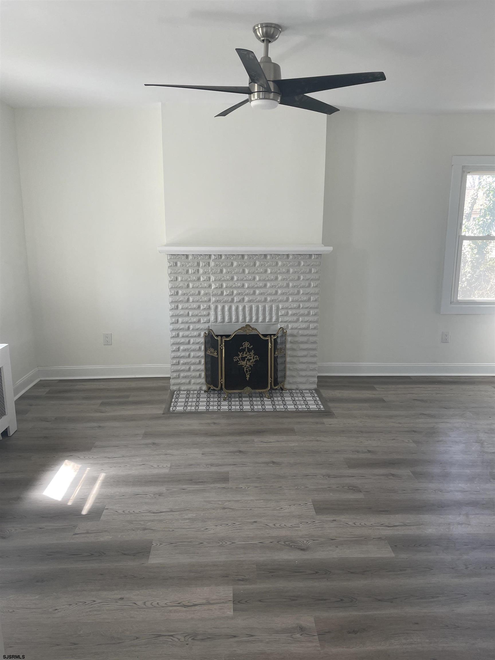 509 Buffalo Avenue Egg Harbor City, NJ 08215 - Photo 2 of 14 a living room with a fireplace and a wooden floor