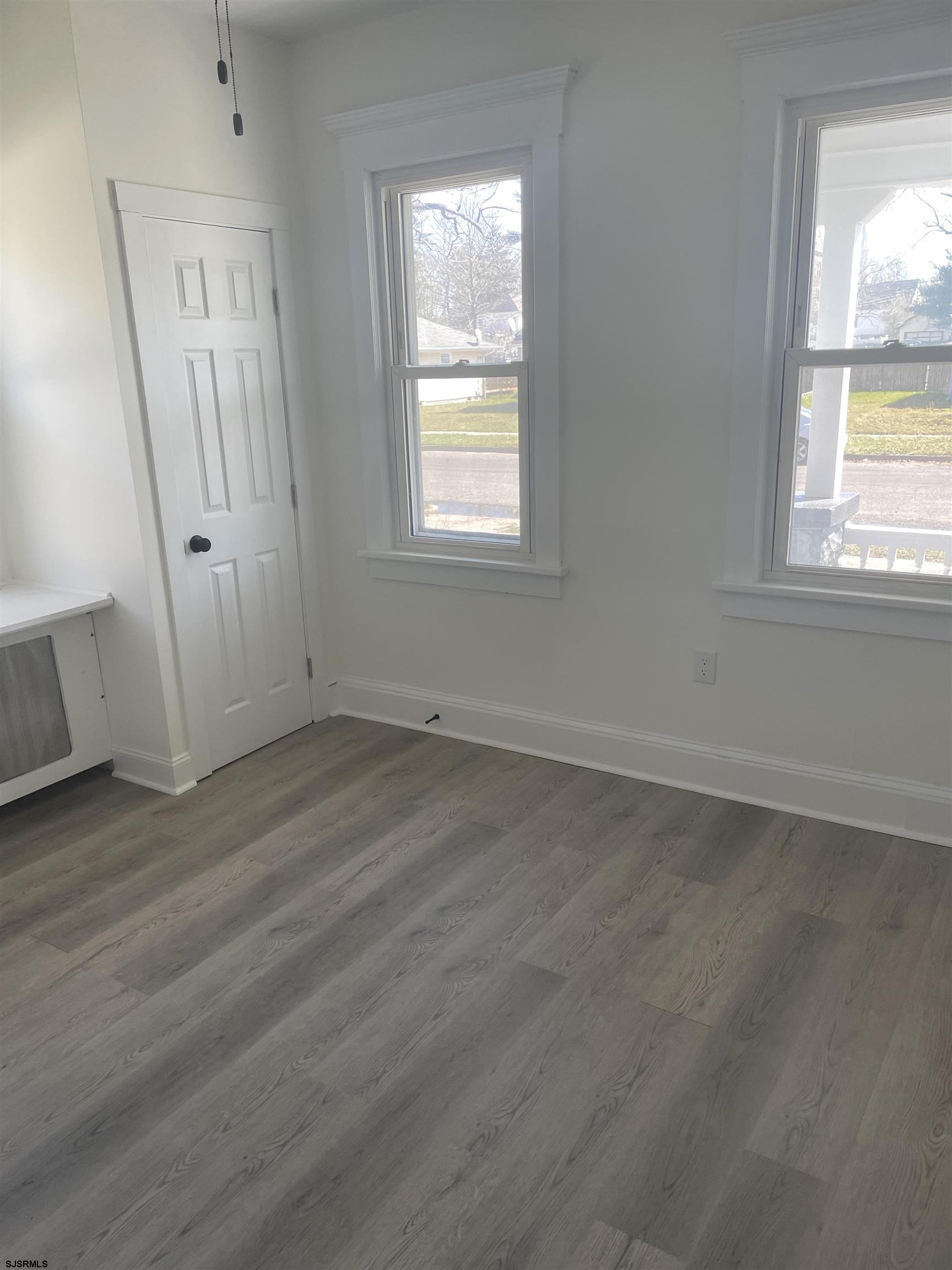509 Buffalo Avenue Egg Harbor City, NJ 08215 - Photo 5 of 14 an empty room with wooden floor and windows