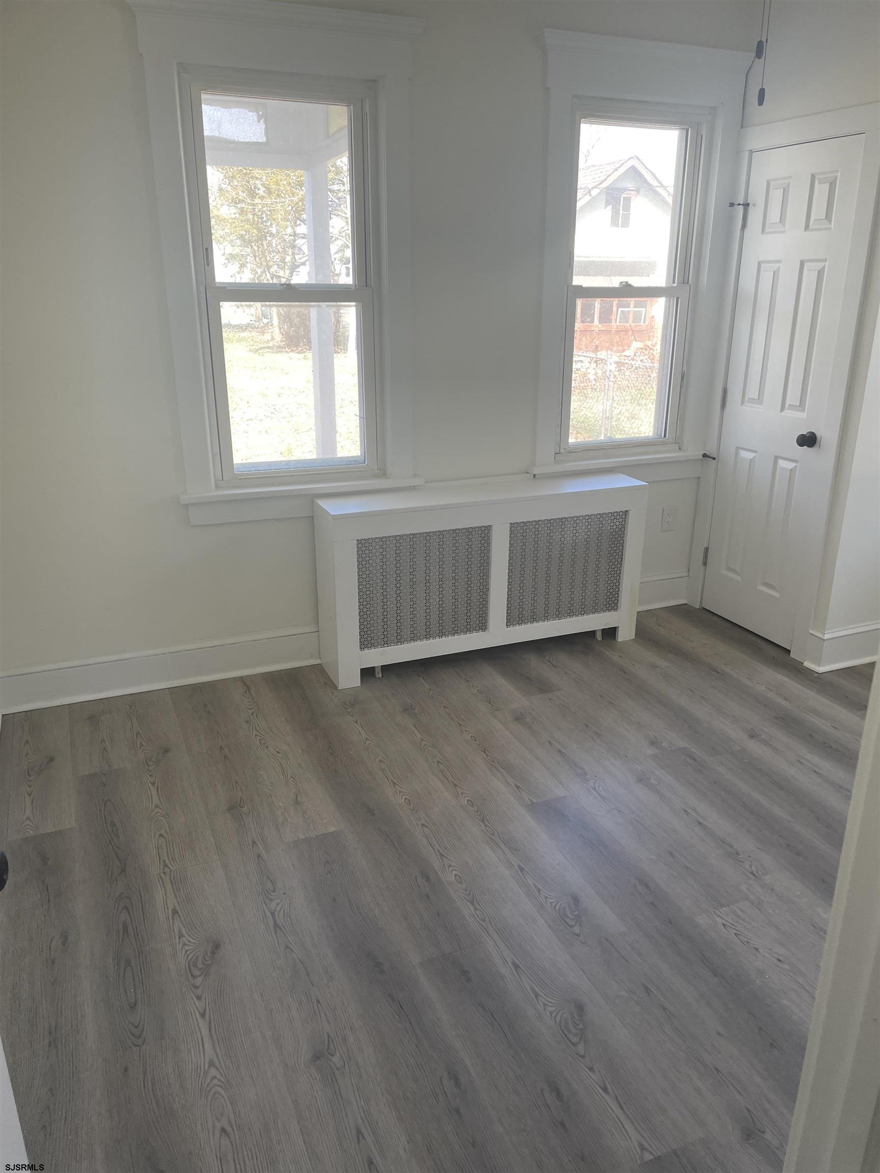 509 Buffalo Avenue Egg Harbor City, NJ 08215 - Photo 6 of 14 an empty room with wooden floor and windows