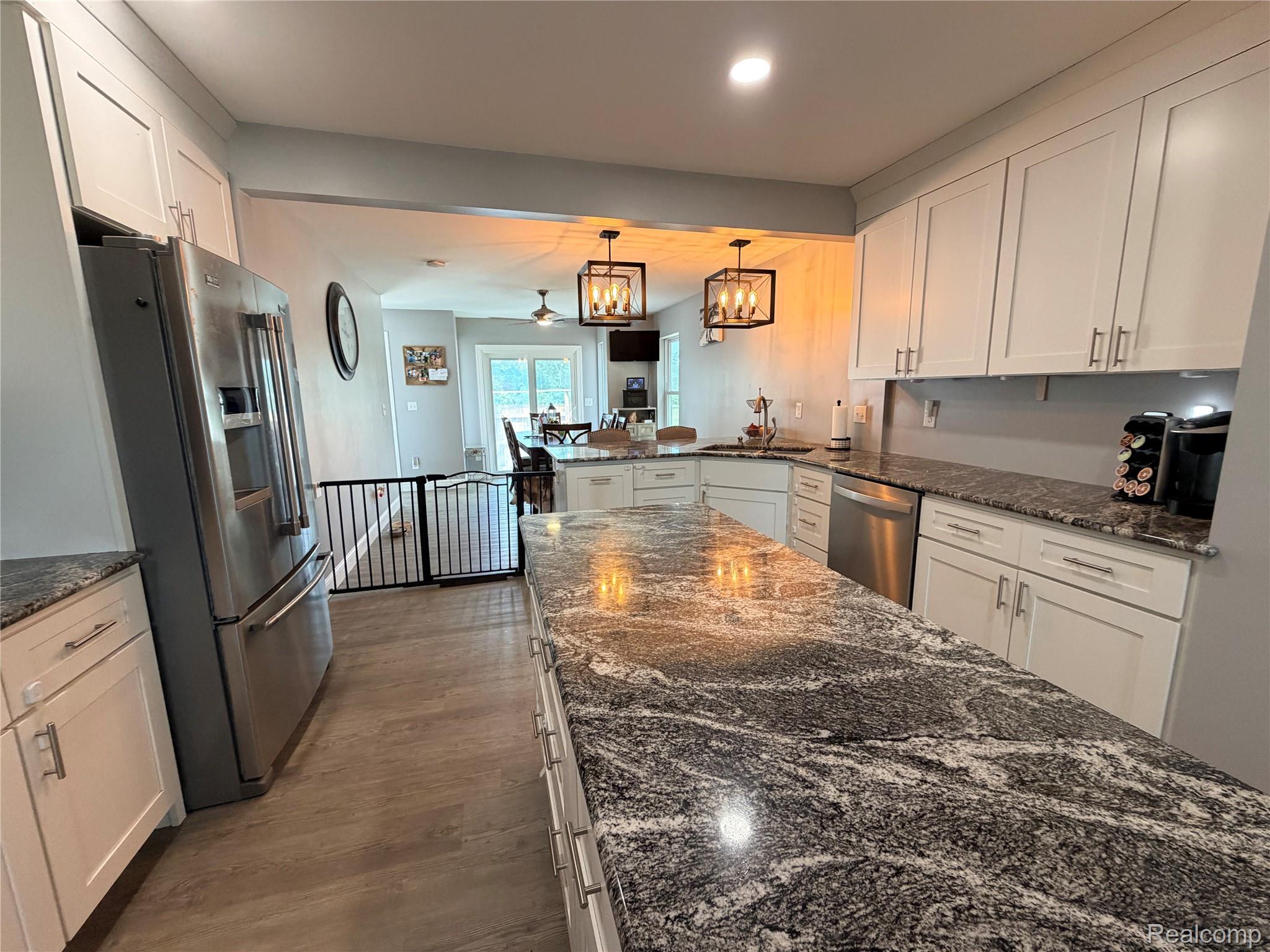 3840 East Dunbar Road Monroe, MI 48161 - Photo 18 of 38 Kitchen featuring extensive countertop space, white cabinetry, stainless steel appliances, wood-finish flooring, and recessed lighting