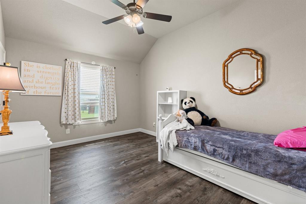 9708 Puma Trail Godley, TX 76044 - Photo 23 of 40 a bed room with a bed and a chandelier