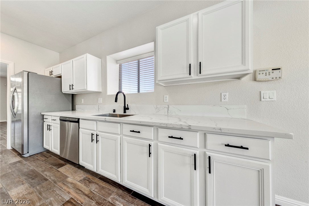 740 Aldo Rae Court, Unit NONE Henderson, NV 89052 - Photo 14 of 35 A well-appointed kitchen showcasing elegant white cabinetry, durable countertops, and sleek stainless steel appliances.
