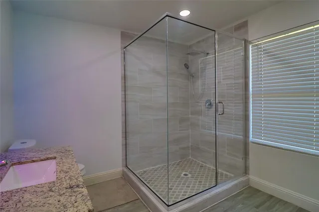 a bathroom with a granite countertop sink toilet and shower