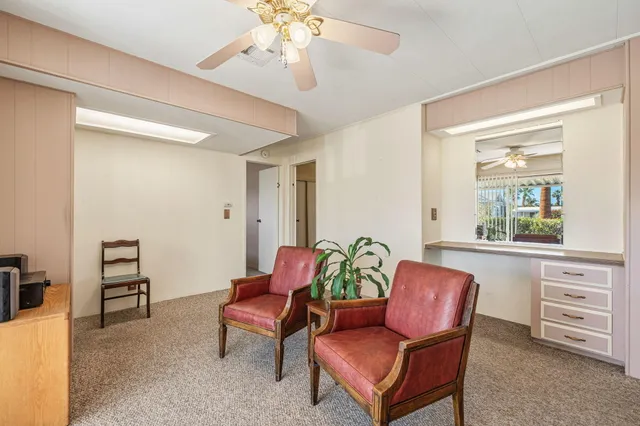 a living room with furniture a flat screen tv and a window