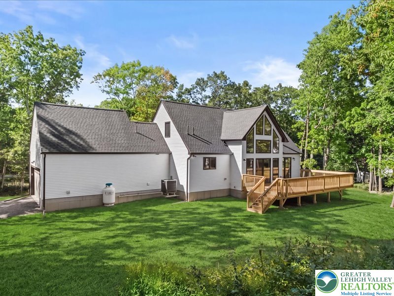 13 Seneca Road Albrightsville, PA 18210 - Photo 2 of 7 A spacious wooden deck overlooks a grassy backyard surrounded by mature trees.