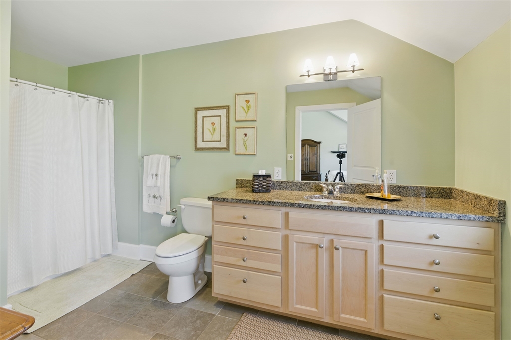2 Powder Mill Square, Unit 2B Andover, MA 01810 - Photo 20 of 31 a bathroom with a granite countertop sink a toilet and a large mirror