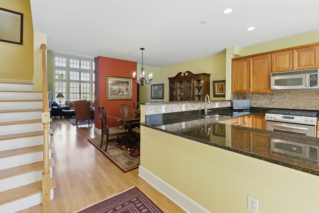 2 Powder Mill Square, Unit 2B Andover, MA 01810 - Photo 3 of 31 a large kitchen with stainless steel appliances granite countertop a sink and cabinets