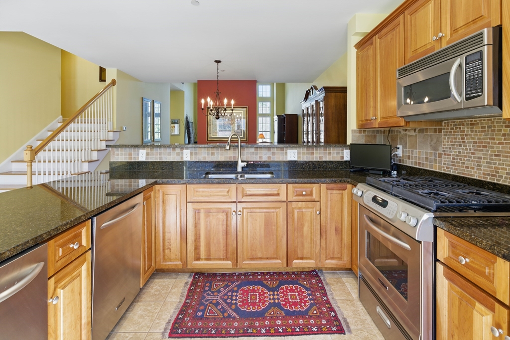 2 Powder Mill Square, Unit 2B Andover, MA 01810 - Photo 4 of 31 a kitchen with stainless steel appliances granite countertop a sink stove and cabinets