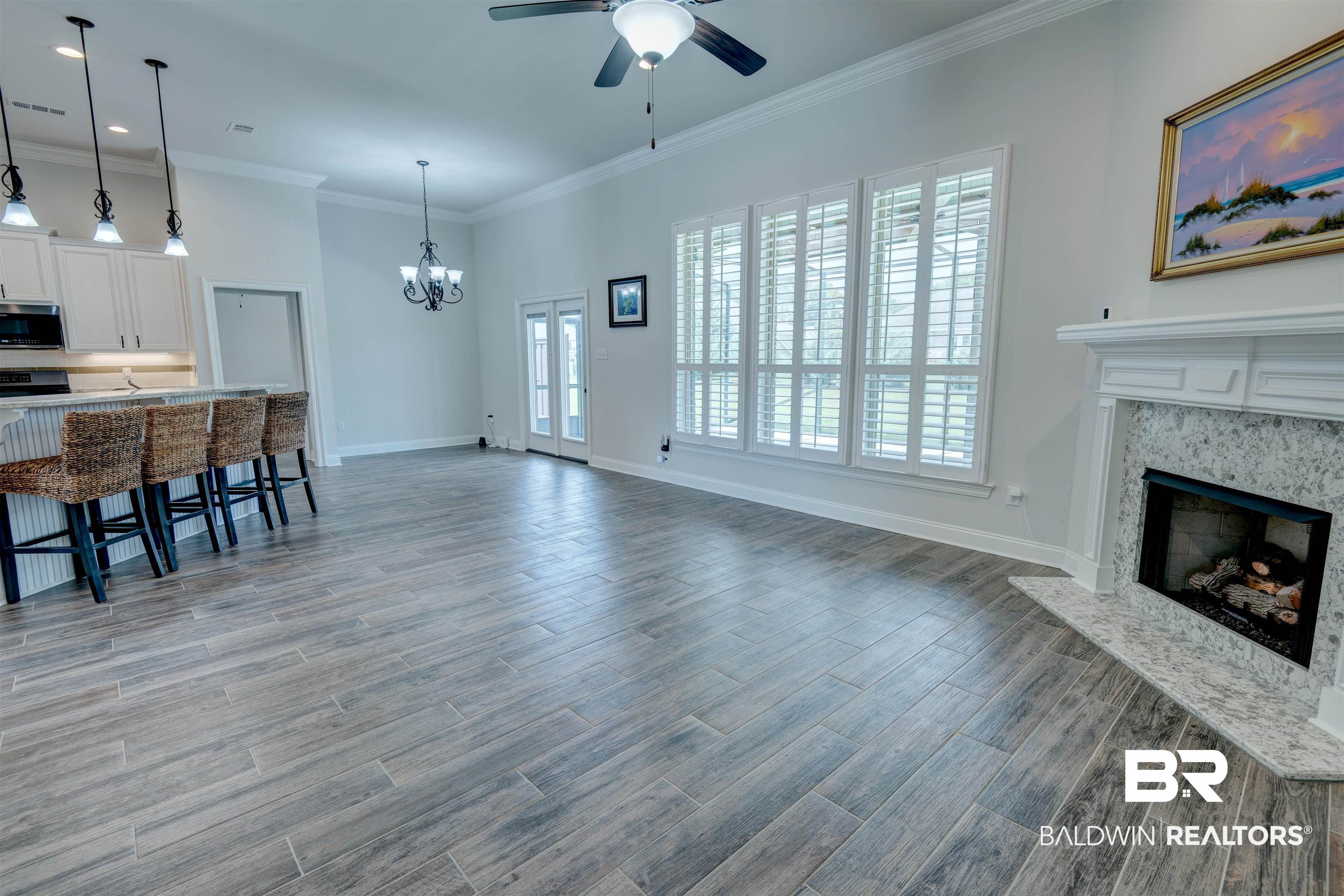 9843 Chipper Lane Foley, AL 36535 - Photo 7 of 34 Living room featuring a chandelier, a ceiling fan, wood finished floors, a high end fireplace, and baseboards