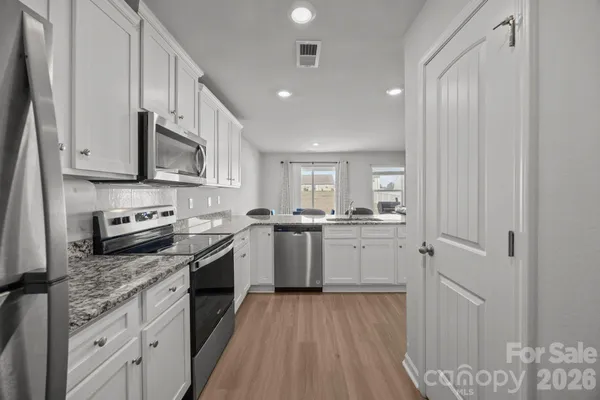 a kitchen with a sink cabinets stainless steel appliances and a window