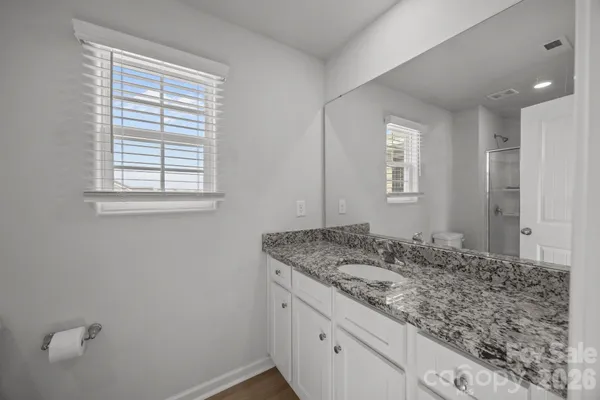 a bathroom with a granite countertop sink and mirror