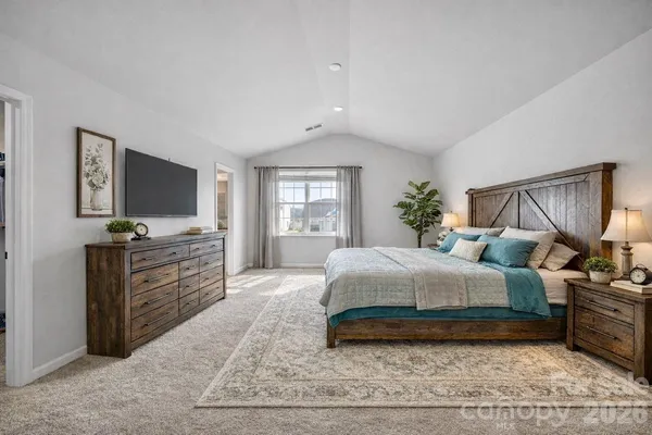 a spacious bedroom with a large bed and a flat screen tv