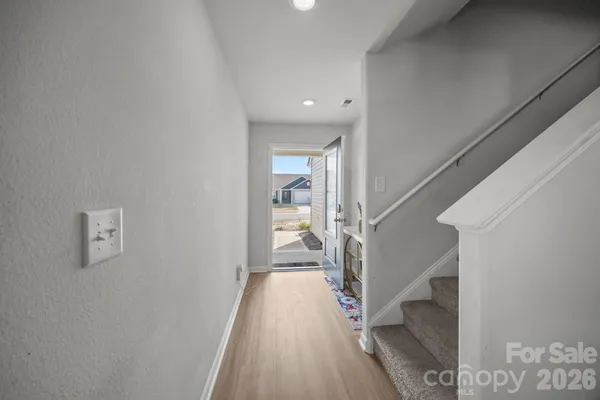 a view of a hallway with wooden floor and staircase