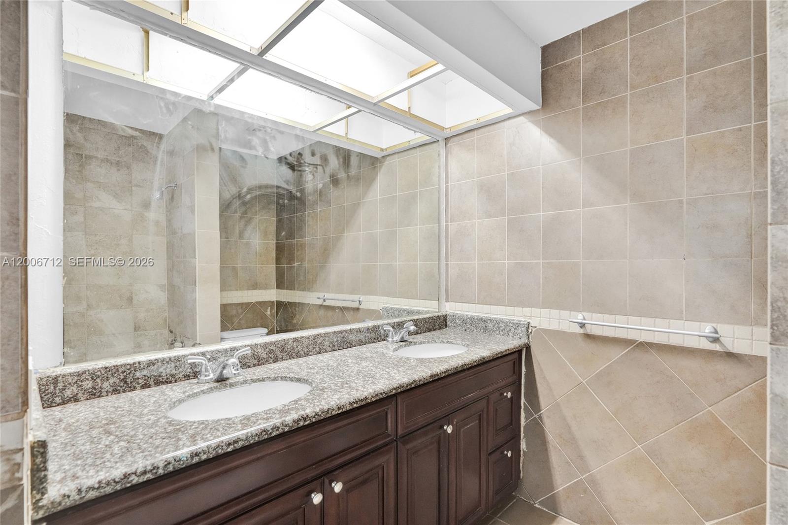 7344 Southwest 82nd Street, Unit C114 Miami, FL 33143 - Photo 19 of 30 a bathroom with a granite countertop sink and a mirror