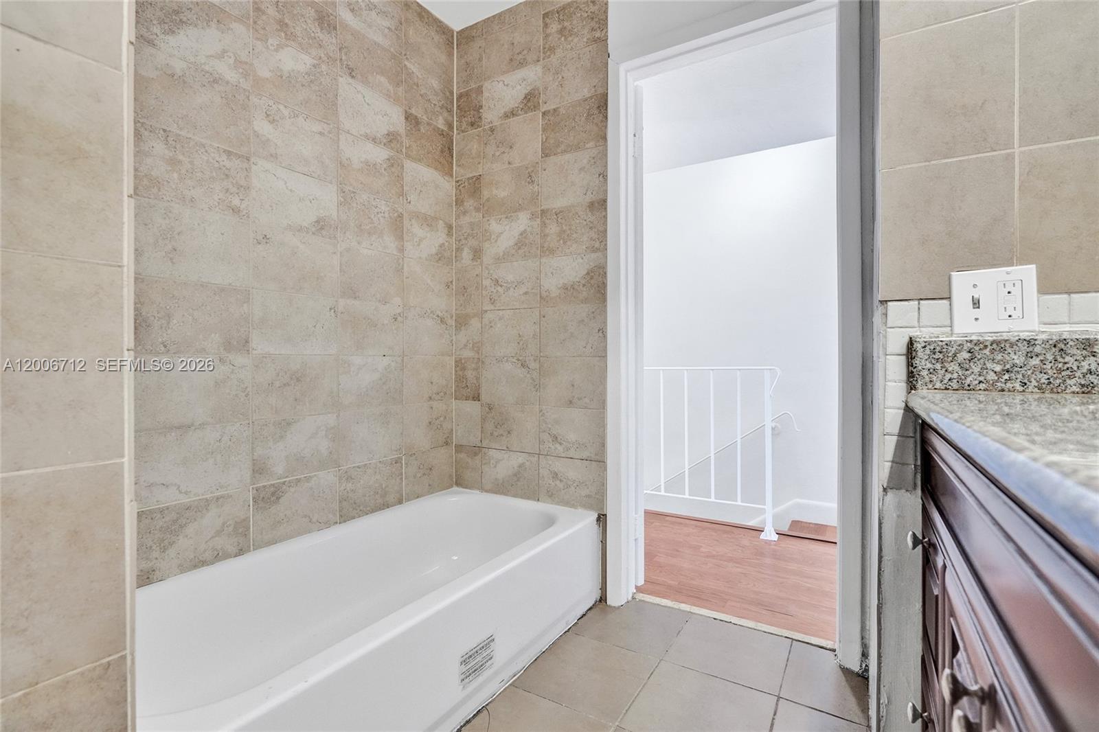 7344 Southwest 82nd Street, Unit C114 Miami, FL 33143 - Photo 20 of 30 a bathroom with a granite countertop bathtub and shower
