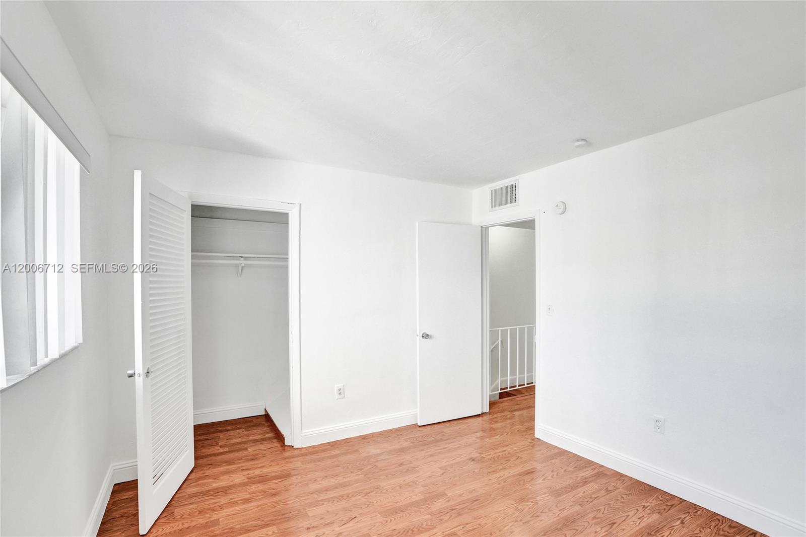 7344 Southwest 82nd Street, Unit C114 Miami, FL 33143 - Photo 22 of 30 an empty room with wooden floor and windows