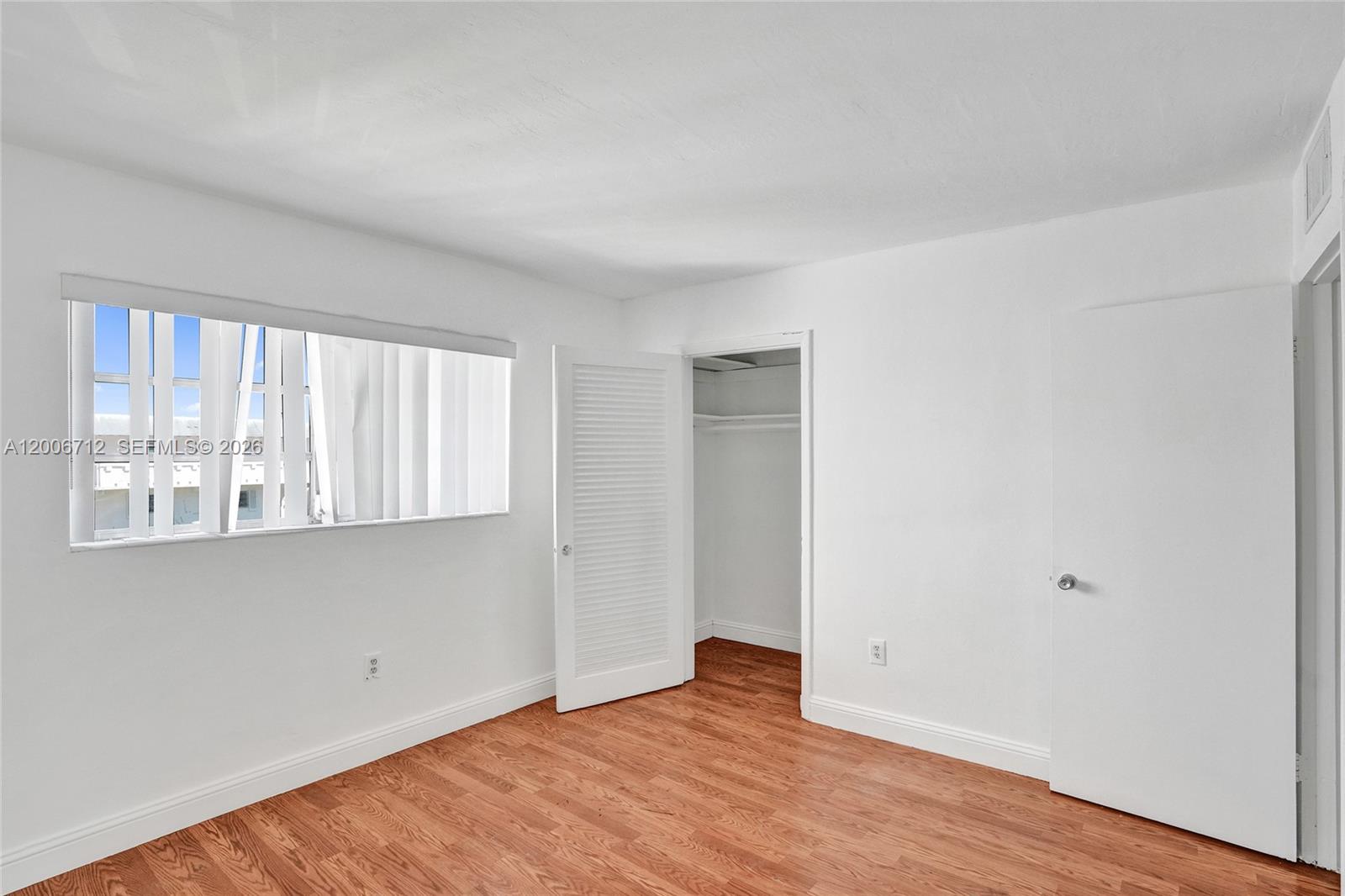 7344 Southwest 82nd Street, Unit C114 Miami, FL 33143 - Photo 23 of 30 an empty room with wooden floor and windows