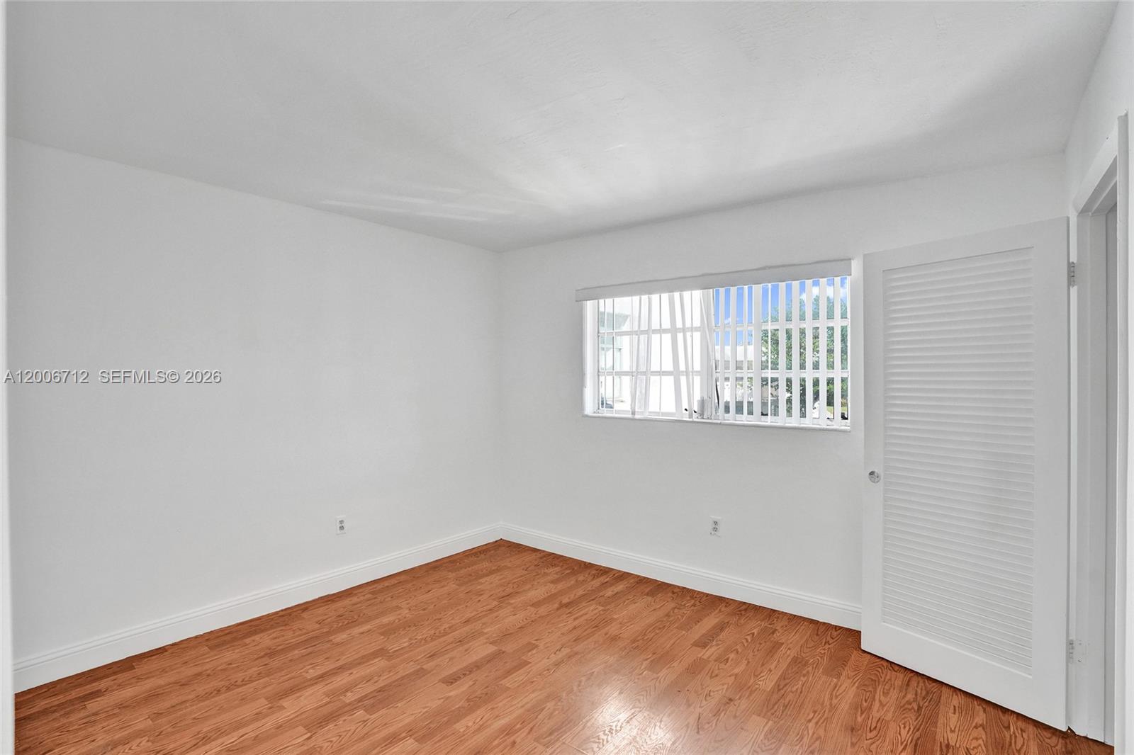7344 Southwest 82nd Street, Unit C114 Miami, FL 33143 - Photo 24 of 30 an empty room with wooden floor and windows