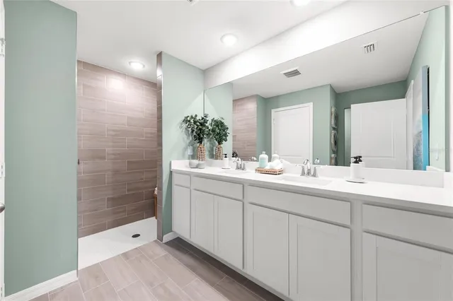 a bathroom with a shower sink and mirror