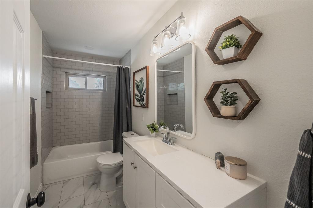 10866 Cassandra Way Dallas, TX 75228 - Photo 13 of 22 a bathroom with a sink a toilet and shower