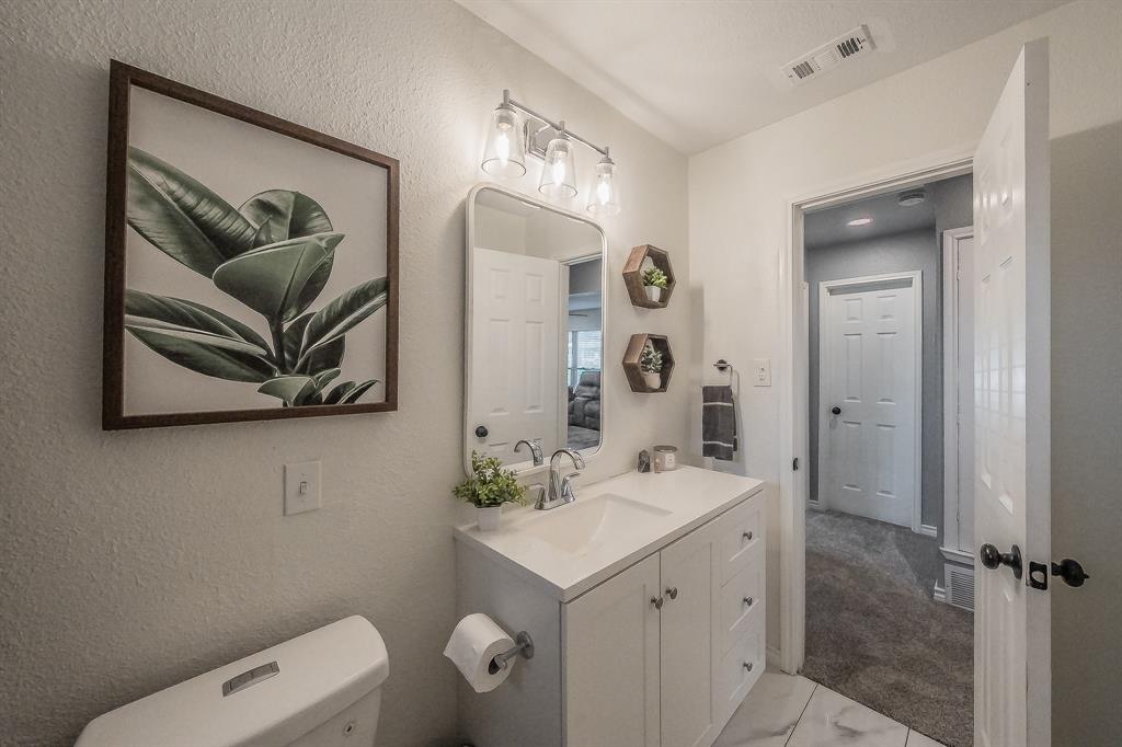 10866 Cassandra Way Dallas, TX 75228 - Photo 14 of 22 a bathroom with a toilet sink and mirror