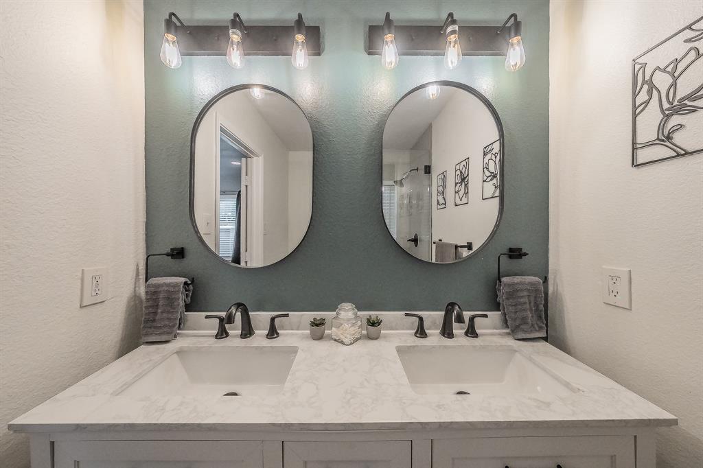 10866 Cassandra Way Dallas, TX 75228 - Photo 17 of 22 a bathroom with double vanity sinks and a mirror