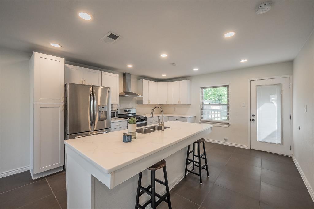 10866 Cassandra Way Dallas, TX 75228 - Photo 3 of 22 a kitchen with a sink a refrigerator and wooden cabinets