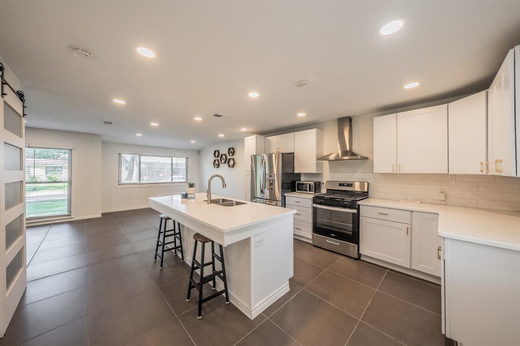 10866 Cassandra Way Dallas, TX 75228 - Photo 4 of 22 a kitchen with a sink white cabinets and stainless steel appliances
