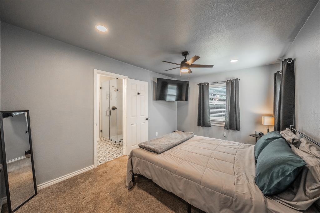 10866 Cassandra Way Dallas, TX 75228 - Photo 9 of 22 a spacious bedroom with a bed and a chandelier