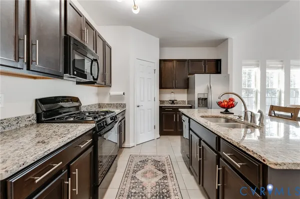 a kitchen with stainless steel appliances granite countertop a stove a sink dishwasher and a refrigerator