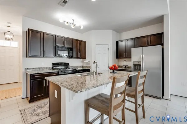 a kitchen with kitchen island a refrigerator stove microwave and cabinets