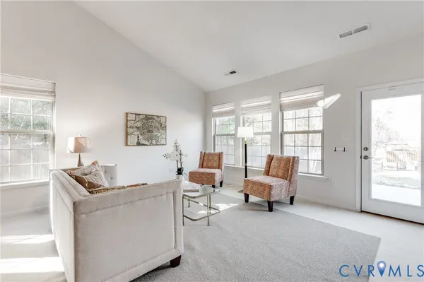 a living room with furniture and large windows