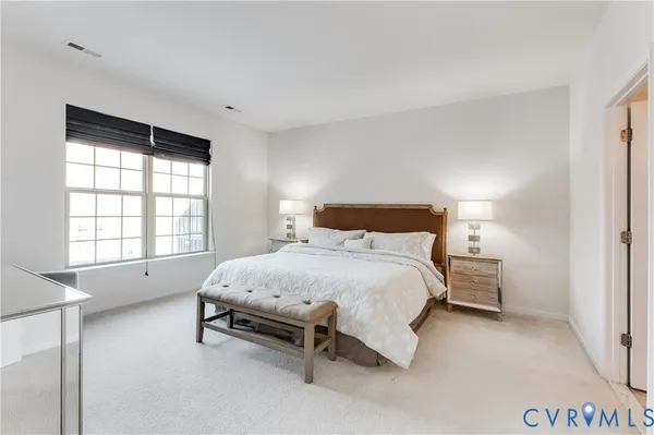 a spacious bedroom with a bed and a window