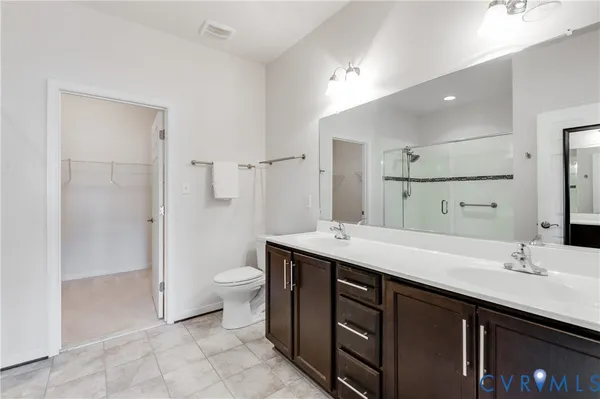 a spacious bathroom with a double vanity sink toilet and shower