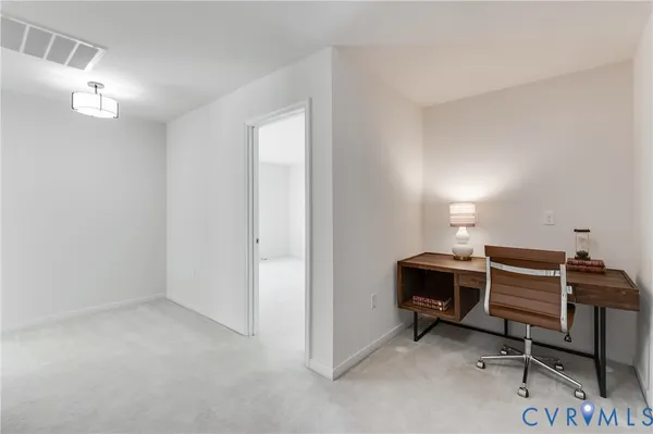 a view of workspace with lounge chair and windows