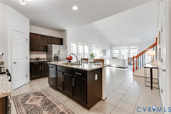 a kitchen with stainless steel appliances kitchen island granite countertop a stove refrigerator and a sink