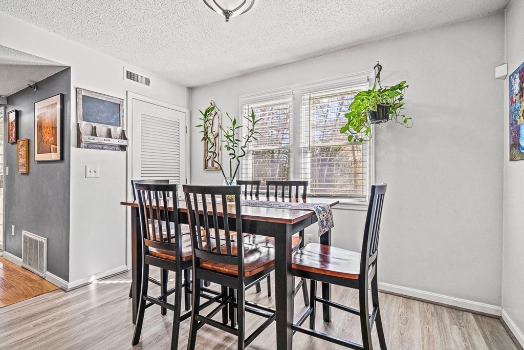 124 Tennis Plaza Road, Unit 21 Dracut, MA 01826 - Photo 11 of 27 a view of a dining room with furniture window and wooden floor