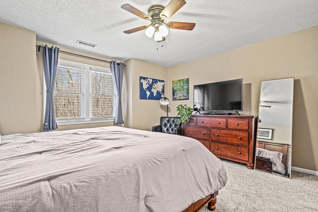 124 Tennis Plaza Road, Unit 21 Dracut, MA 01826 - Photo 20 of 27 a bedroom with a bed and a flat screen tv